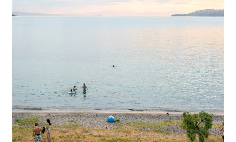 Swimmers in Lake Taupo in the dusk.