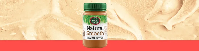 A jar of Mother Earth Natural Smooth Peanut Butter is shown against a background of creamy peanut butter with a red border at the bottom.