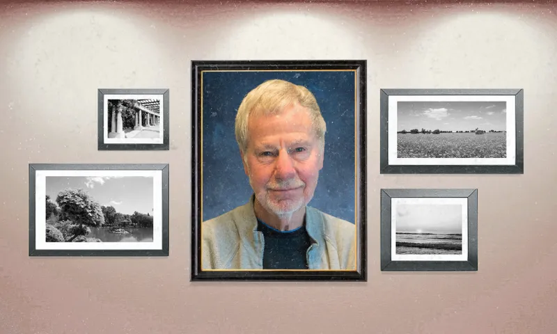 a makeshift photo wall with black and white landscapes and one large school-style portrait of a man with white hair, a white beard and a collared shirt