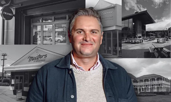 a man in a collared shird, sweater and jacket smiles at the camera. he has short hair and dark eyebrows. in the background, a black and white collage of restaurant frontages