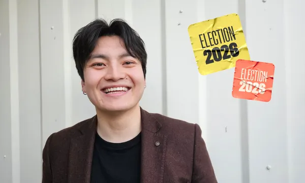 A person smiling in front of a light-colored wall, with two stickers that read “Election 2026” and “Election 2028” floating beside them.