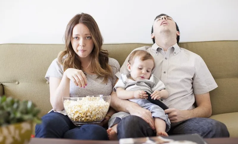 Young couple with baby boy (6-11 months) watching TV