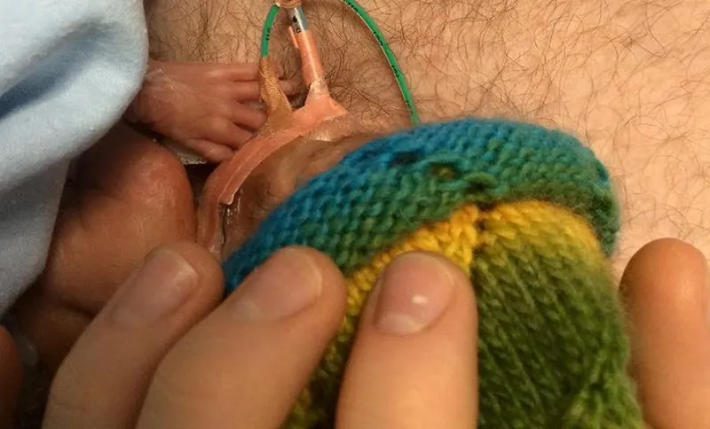 Baby Charlie is cradled by his dad.