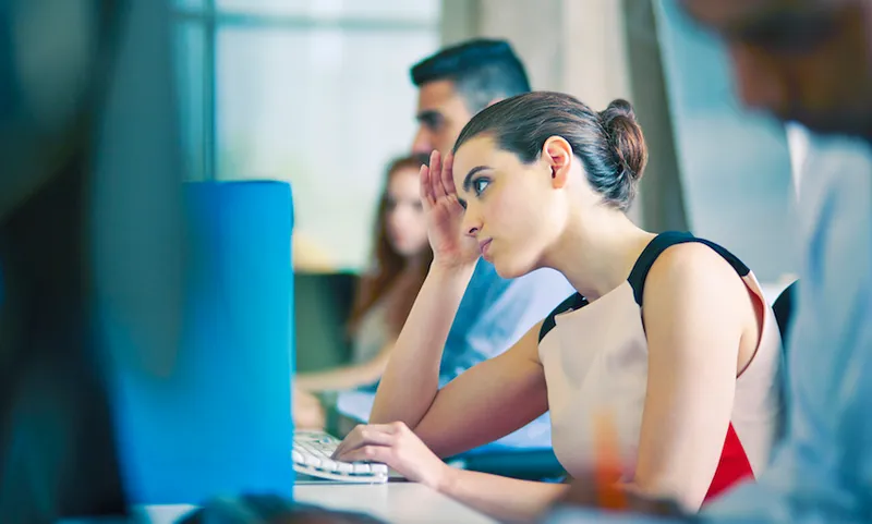 Woman at desk, staring at computer screen