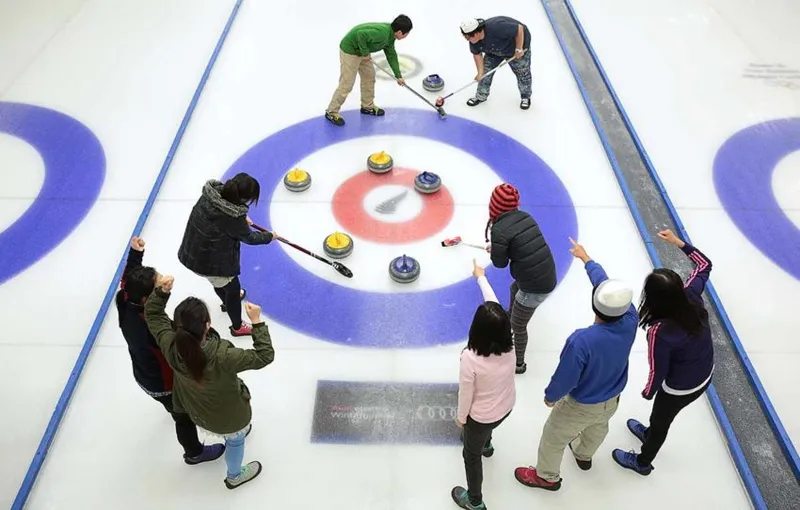 A close curling match between a group of friends at the indoor ice rink in Naseby, Central Otago.