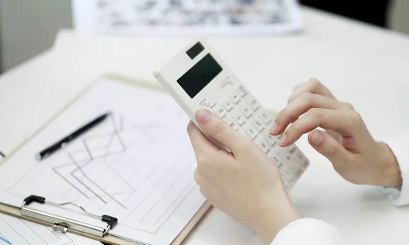 Businesswoman using calculator in office
