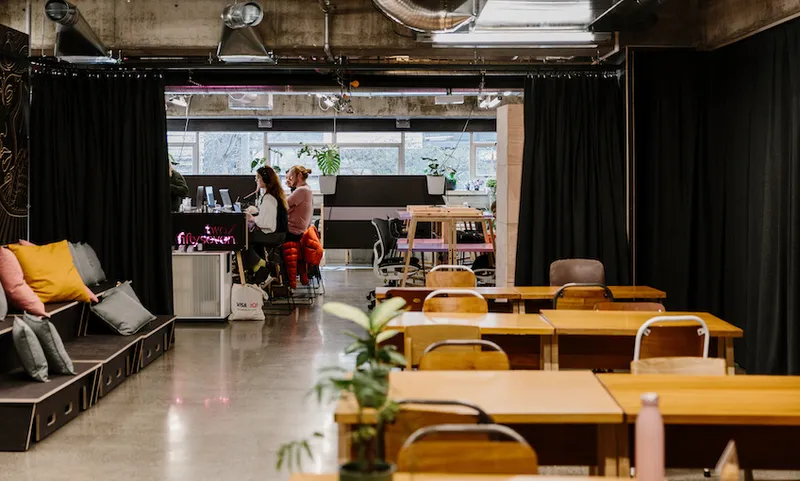 A row of tables and two people working side by side at two/fiftyseven.