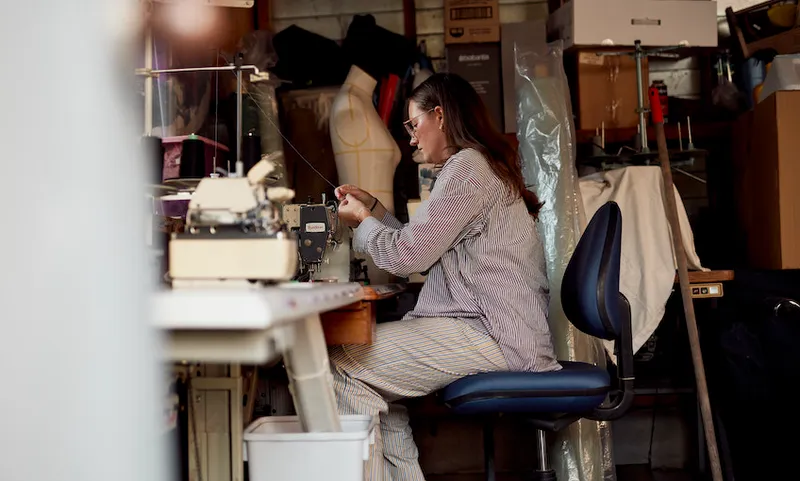 Whitney Barnes sits at her sewing machine making clothes in her garage.