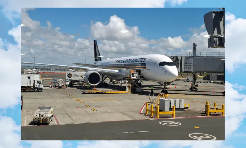 A Singapore Airlines jetliner is parked at the airport gate, connected to a jet bridge. Ground vehicles and equipment surround the aircraft under a partly cloudy blue sky.