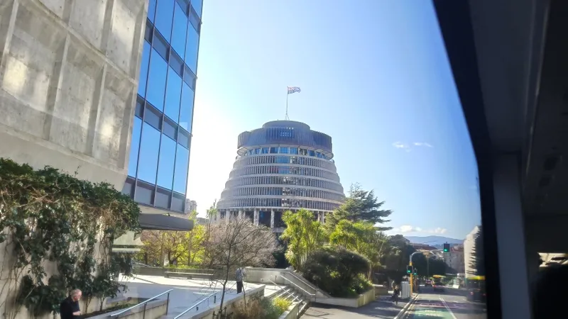 New Zealand's Beehive building on a sunny day with the flag flying.