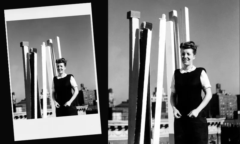 A woman in a dark dress and white blouse stands smiling in front of tall, vertical white sculptures on a rooftop, with city buildings visible in the background. An angled version of the same photo appears on the left.