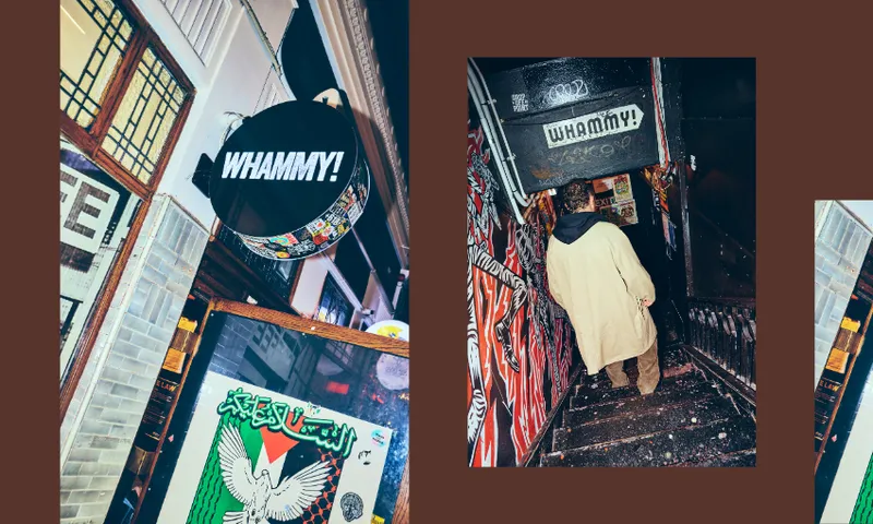 A person in a beige coat walks down graffiti-covered stairs under a "WHAMMY!" sign; on the left, a close-up of the same sign hangs outside a building above a colorful poster.