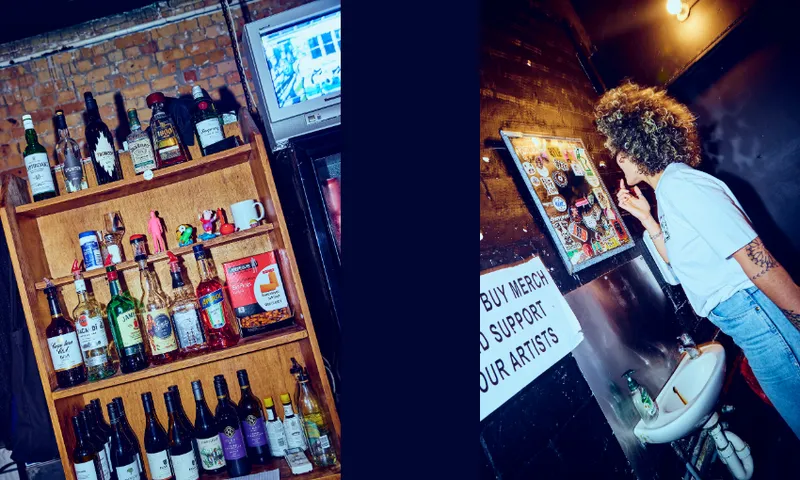 A split image: on the left, a shelf with assorted liquor bottles beneath a mounted TV; on the right, a person with curly hair looks at a sticker-covered mirror above a small sink in a dimly lit room.