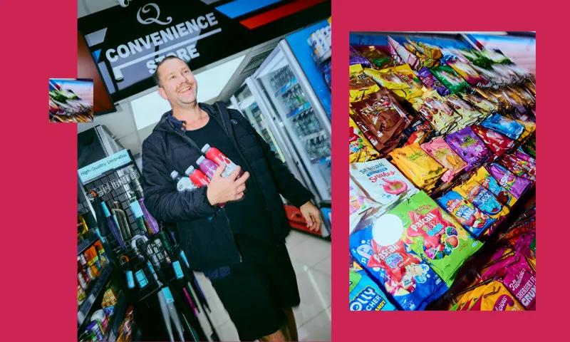 A smiling man holding drinks walks through a convenience store aisle filled with drinks, while brightly colored candy bags are displayed on a counter to the right.