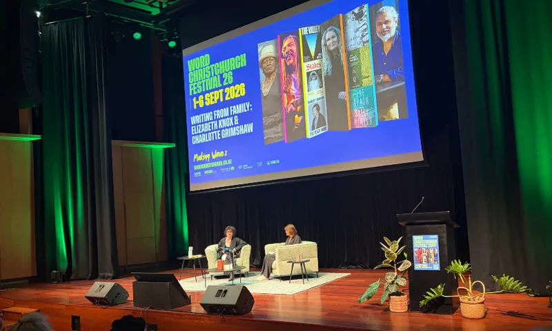 A photo of a stage with two writers in arm chairs.