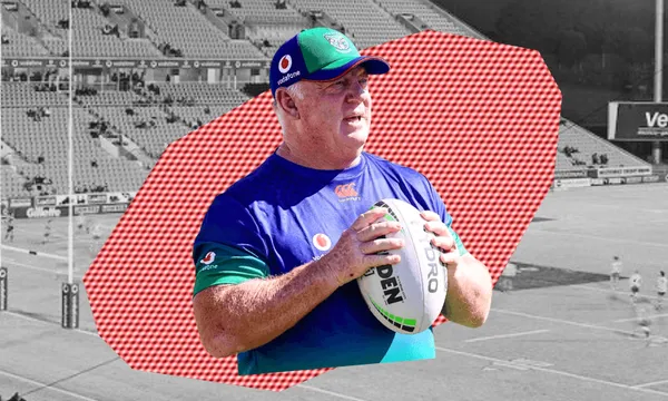 A rugby league coach in a blue and green shirt and cap holds a rugby ball, standing in front of a stylised stadium background with a red geometric overlay.