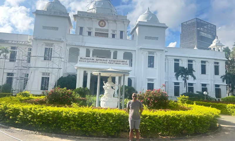 A photo of Brannavan Gnanalingam, an author, standing in front of an historic public library in Jafna, Sri Lanka.