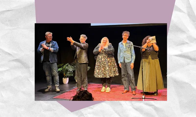 five people stand on stage applauding wearing smart casual clothing