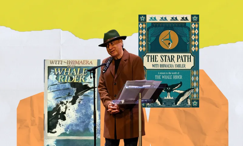 Witi Ihimaera stands to speak at a standing microphone. There's a music stand with paper on it in front of him. He's wearing a hat and brown coat. Behind him are covers of his books The Whale Rider, and The Star Path.