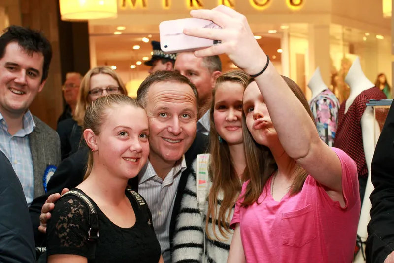A man takes a selfie with a woman and some girls