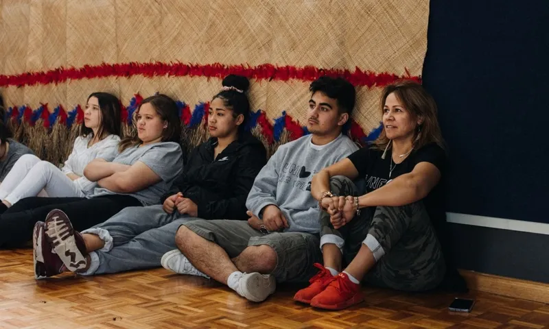 Huia O’Sullivan sits on the floor alongside a group of rangatahi during a Ngā Rangatahi Toa workshop.