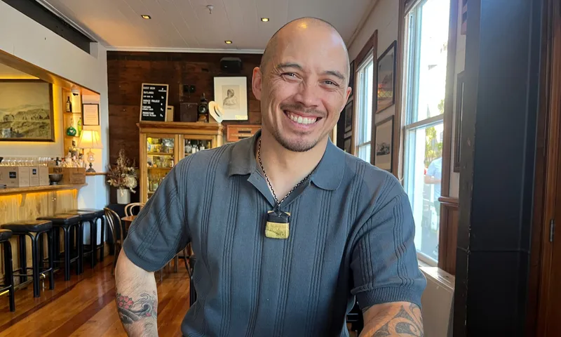 A young Maaori man smiles brightly.