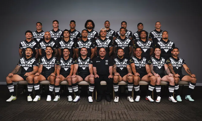 A formal, three-tiered team portrait of the New Zealand Kiwis rugby league squad, featuring 22 players in black and white chevron jerseys and one coach seated in the center.