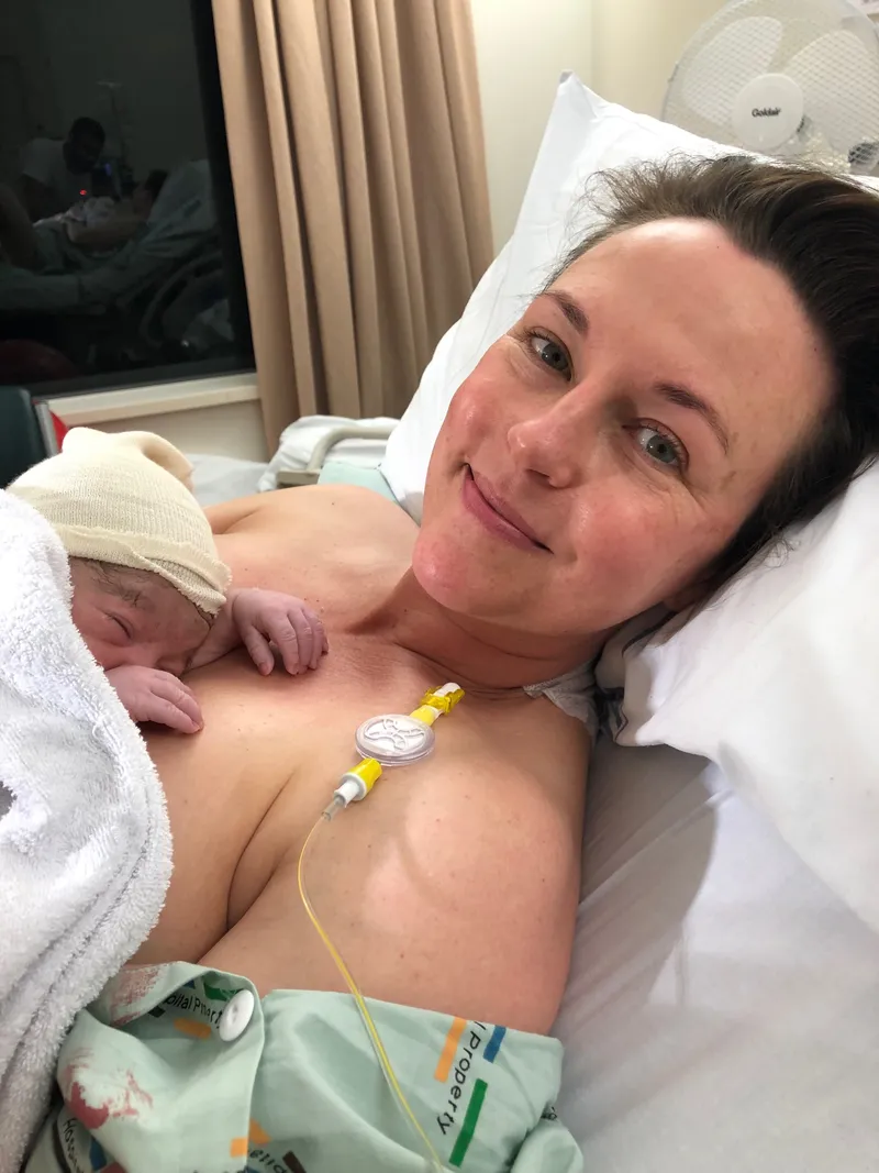 A woman lying in hospital with a newborn on her chest