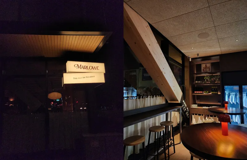 A lit-up sign saying Marlowe, this must be the place against a dark background is on the left of the image. On the right, the interior of a restaurant, with barstools, wine bottles and a fridge with fish dry-ageing is visible.