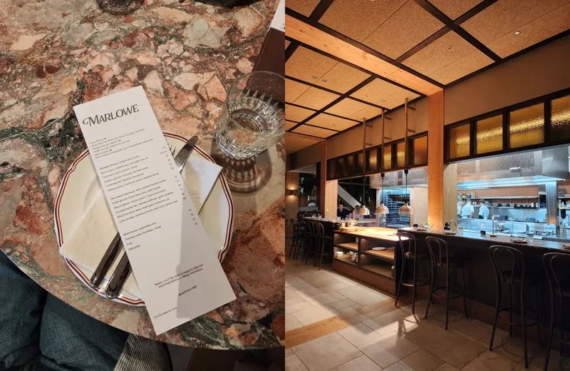 A menu and dinner setting against a marble table is on the left. On the right, a restaurant's open kitchen with bar seating.
