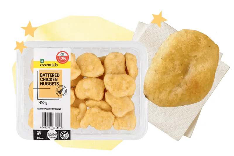 A box of Woolworths Essentials chicken nuggets alongside a cooked nugget.
